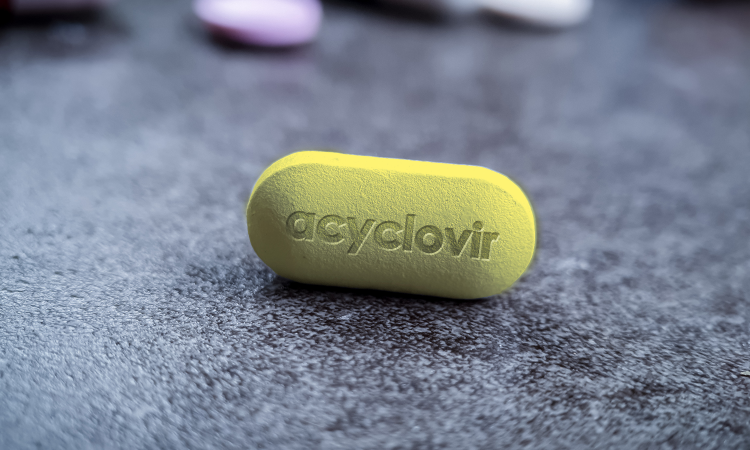 capsula amarela em cima da mesa com a escrita acyclovir