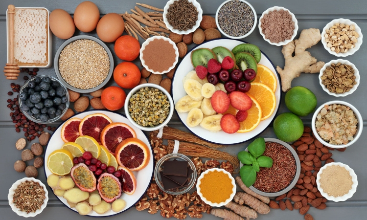mesa com diversos alimentos como proteinas, frutas, grãos e verduras
