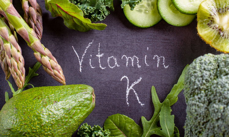 Escrita vitamina K com diversas frutas e verduras da cor verde