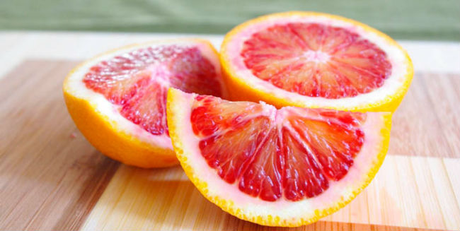 foto de três laranjas cortadas ao meio das cores vermelhas e laranjas